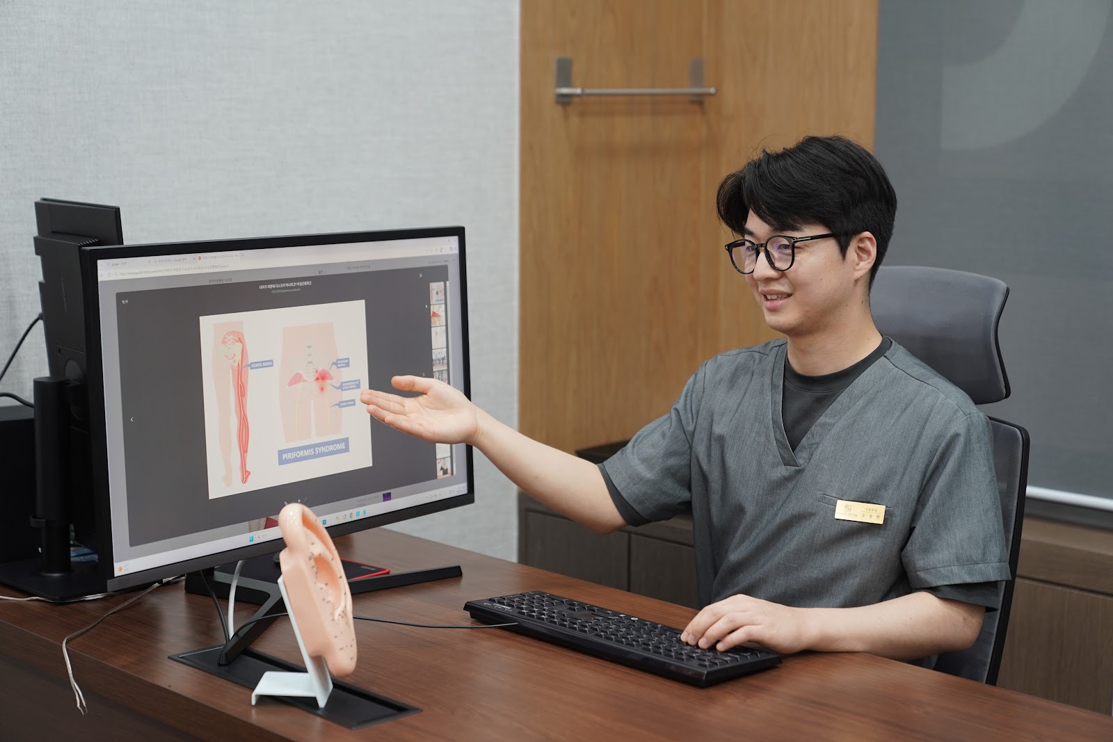한의사가 입원 환자에게 척추 모형으로 상태를 설명하는 모습