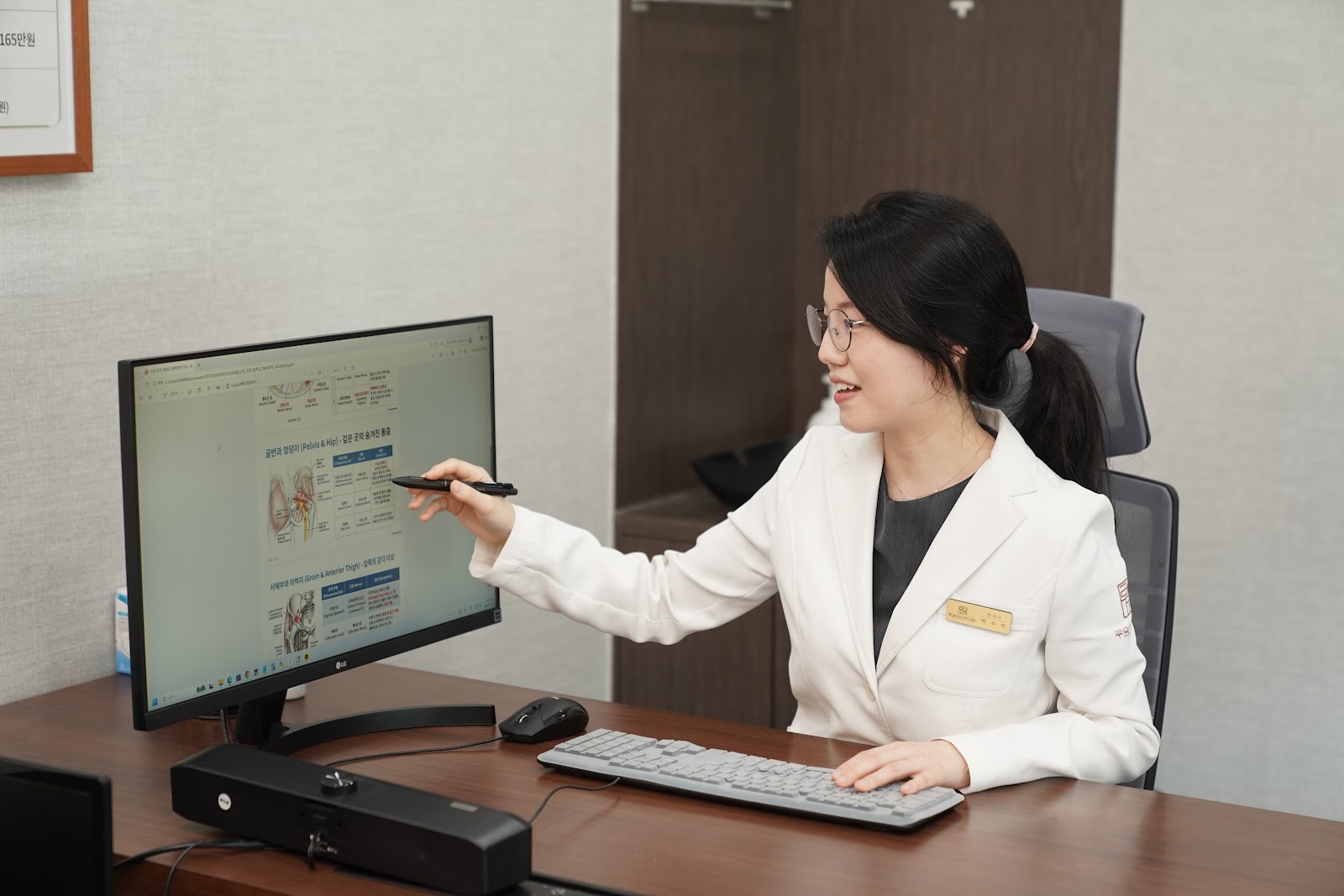 한의사가 모니터로 치료 경과를 함께 확인하는 상담 장면